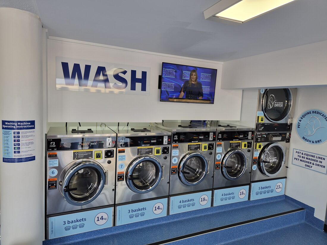 Bright, clean laundromat interior with folding bench and seating